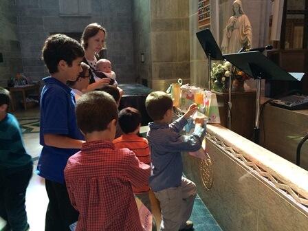 Children collected prayer pledges in baby gift bags and then placed them at the foot of the Blessed Mother's statue