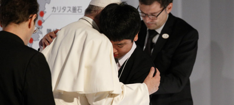 Pope Francis embraces a young man as he meets with victims of the 2011 "triple disaster" (earthquake, tsunami and nuclear power plant meltdown) at Bellesalle Hanzomon, Tokyo, Japan, Nov. 25, 2019.